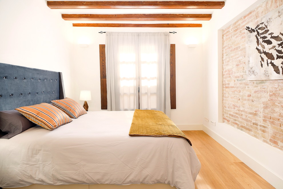 Foto de dormitorio principal urbano de tamaño medio con paredes blancas, suelo de madera en tonos medios y suelo beige