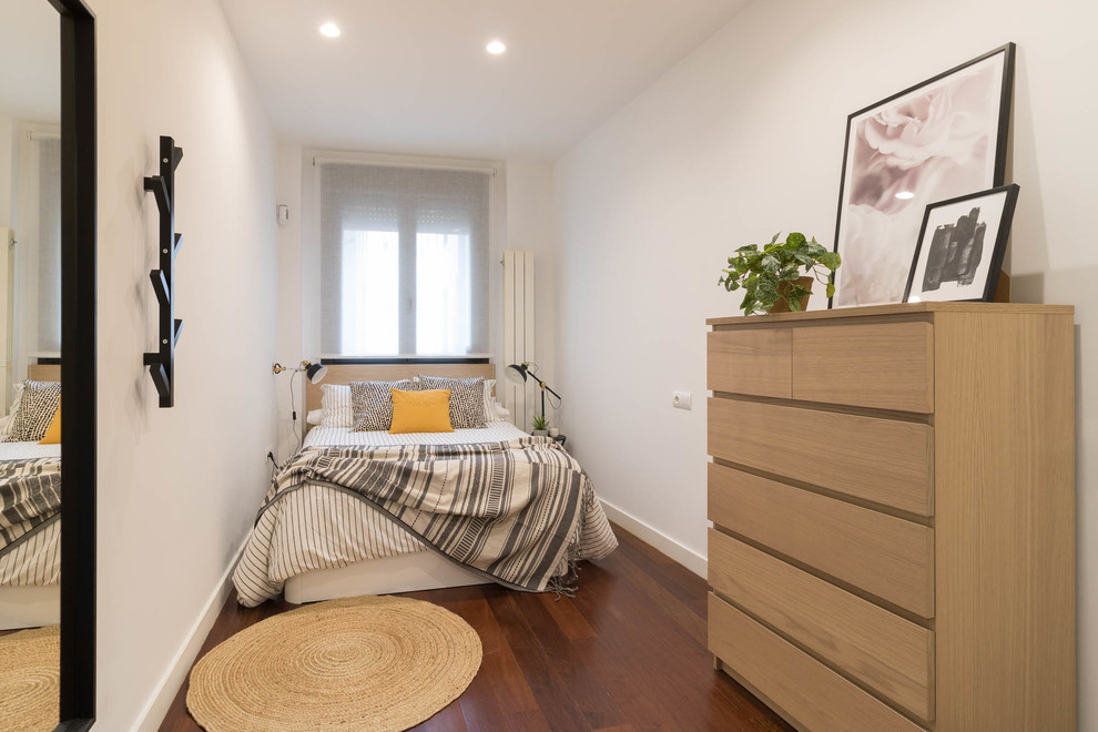 Scandinavian guest and grey and brown bedroom in Other with white walls, dark hardwood flooring and brown floors.