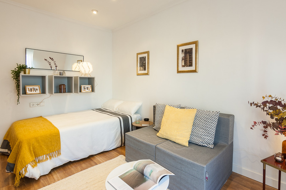 Idee per una camera da letto stile loft contemporanea con pareti bianche, pavimento in laminato, nessun camino e pavimento marrone