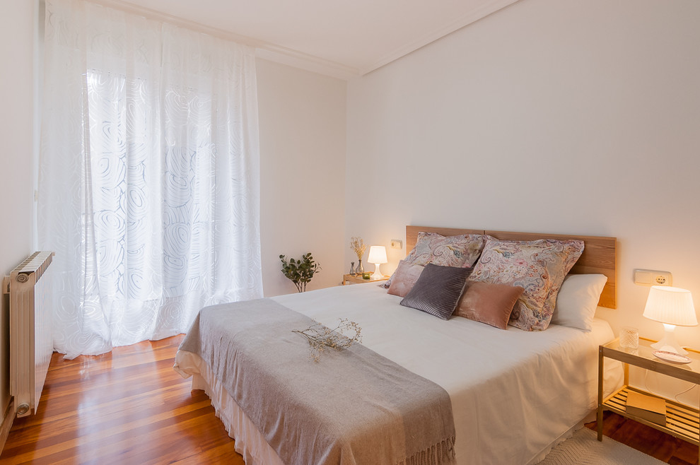 На фото: хозяйская спальня в современном стиле с белыми стенами, паркетным полом среднего тона и коричневым полом без камина с