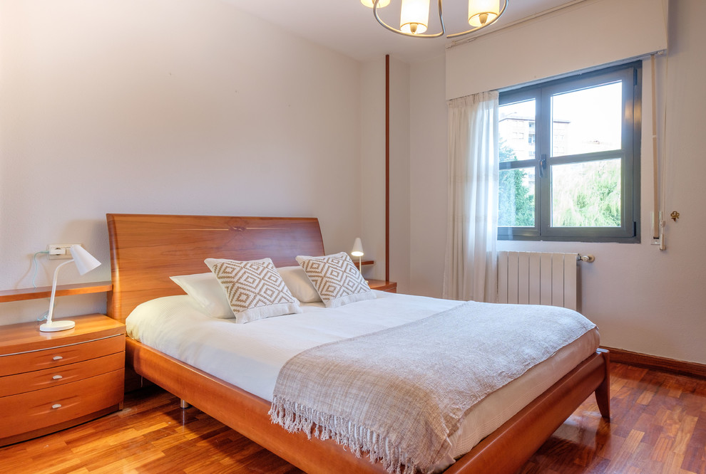 Ejemplo de dormitorio escandinavo con paredes blancas, suelo de madera en tonos medios y suelo marrón