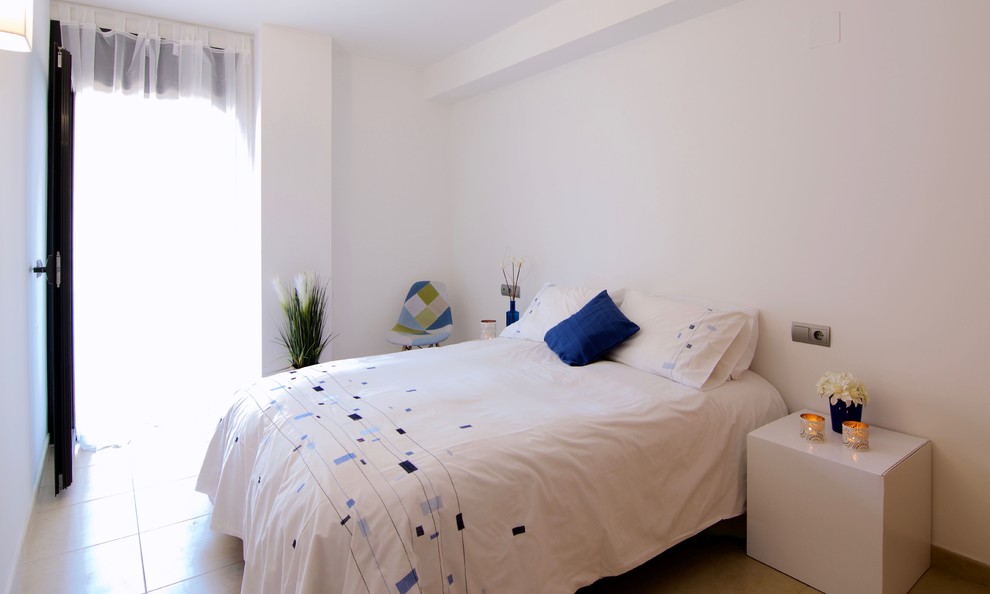 Ejemplo de dormitorio principal minimalista de tamaño medio con paredes blancas, suelo de baldosas de cerámica y suelo beige