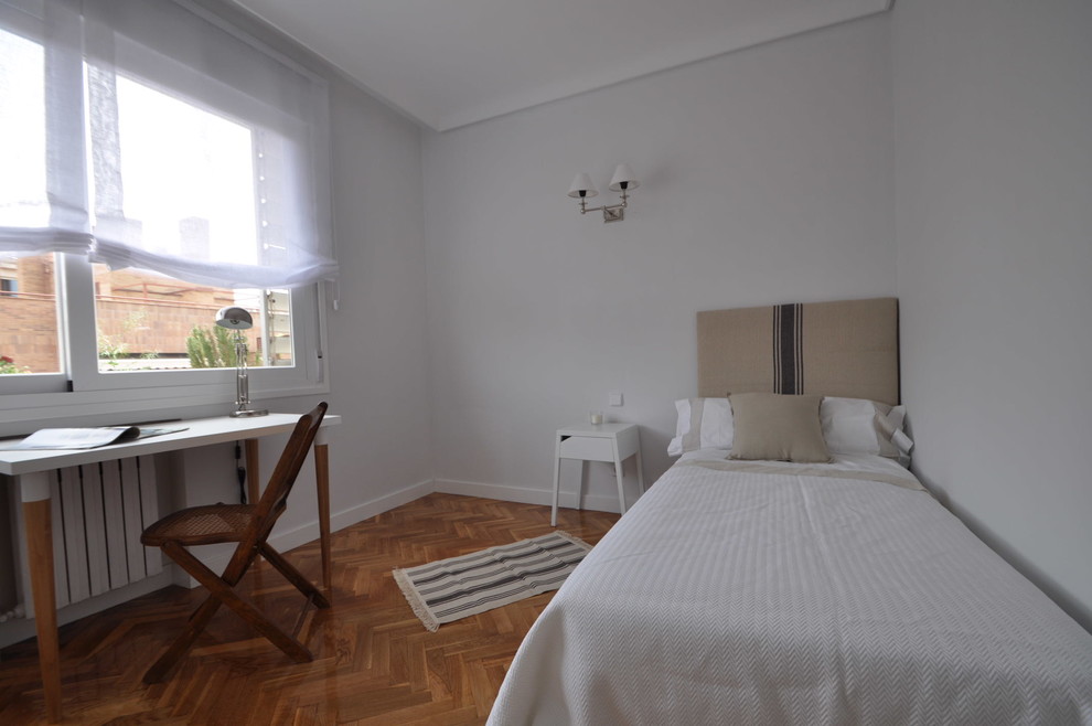 Modelo de dormitorio principal tradicional renovado pequeño sin chimenea con suelo de madera en tonos medios
