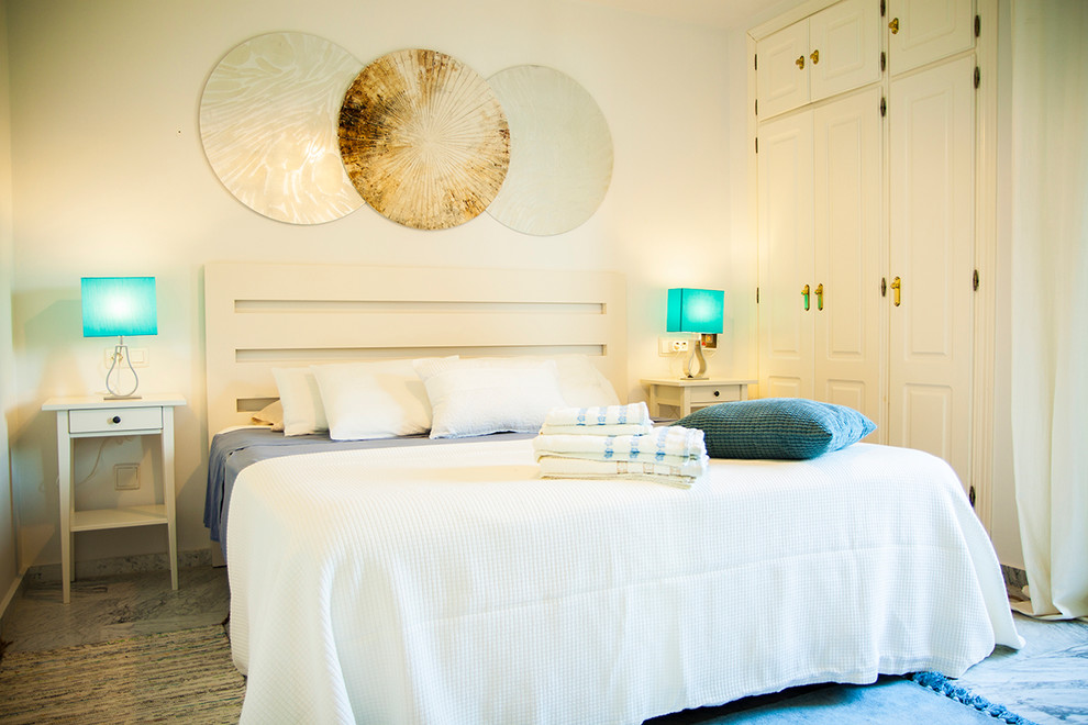 他の地域にある小さなビーチスタイルのおしゃれな主寝室 (白い壁、大理石の床、グレーの床) のレイアウト
