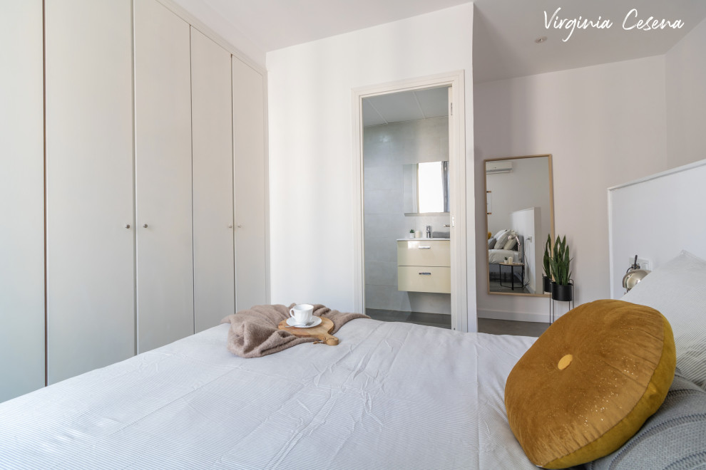 This is an example of a medium sized scandi master bedroom in Barcelona with white walls, concrete flooring and grey floors.