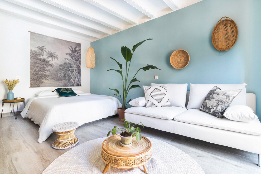 他の地域にあるトロピカルスタイルのおしゃれな主寝室 (青い壁、暖炉なし、ベージュの床)