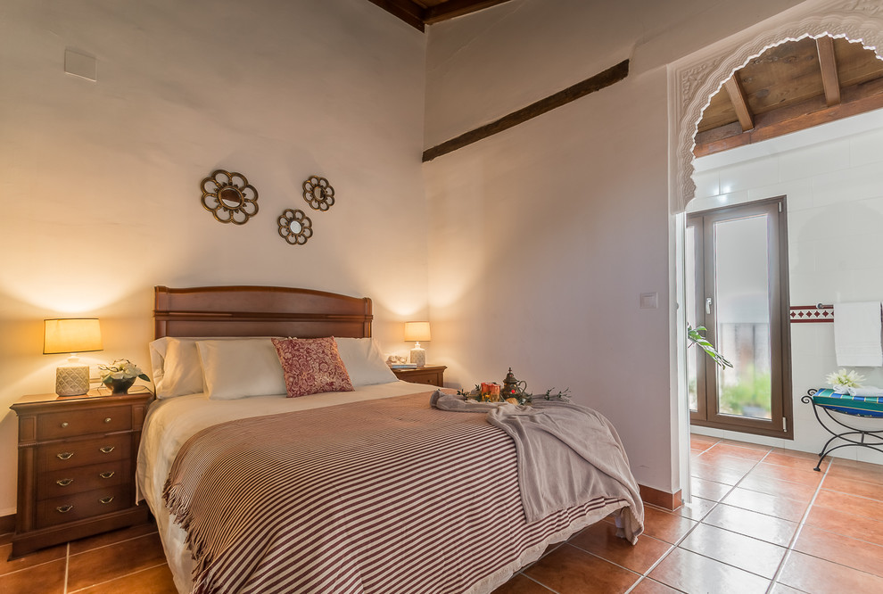 Свежая идея для дизайна: маленькая гостевая спальня (комната для гостей) в стиле неоклассика (современная классика) с белыми стенами, полом из терракотовой плитки и коричневым полом для на участке и в саду - отличное фото интерьера