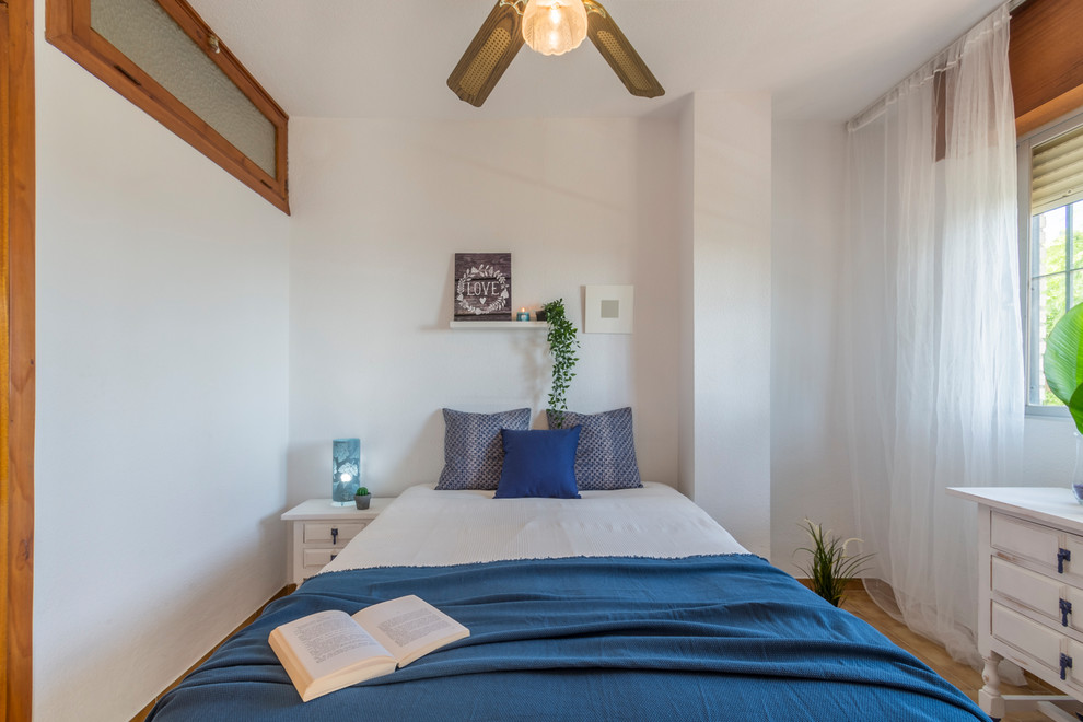 Imagen de dormitorio principal costero de tamaño medio con paredes blancas, suelo de baldosas de terracota y suelo beige