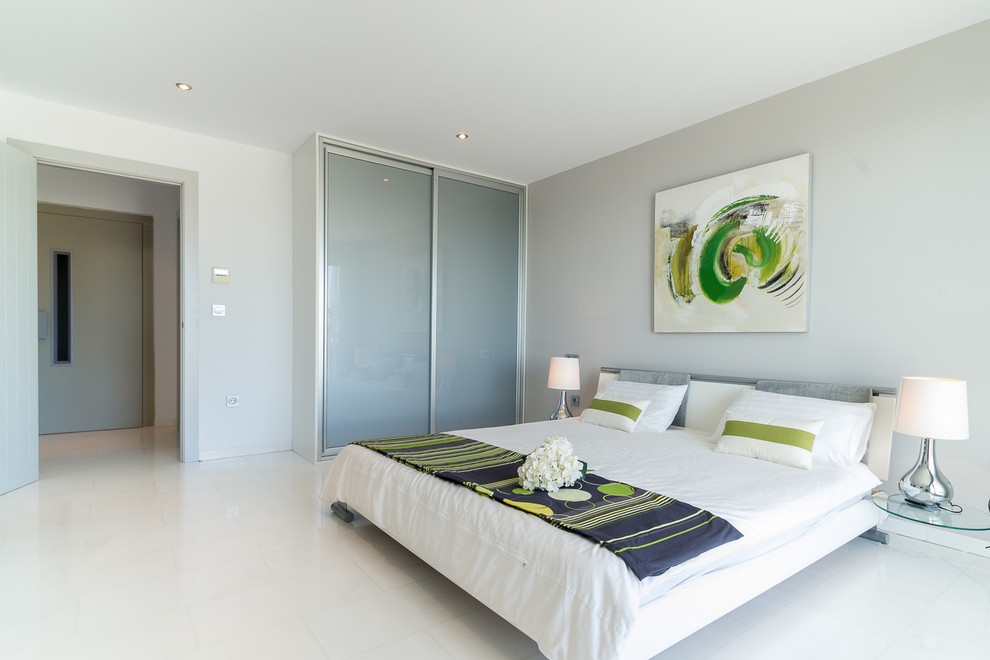 Esempio di una grande camera degli ospiti design con pareti bianche, pavimento in marmo e pavimento bianco
