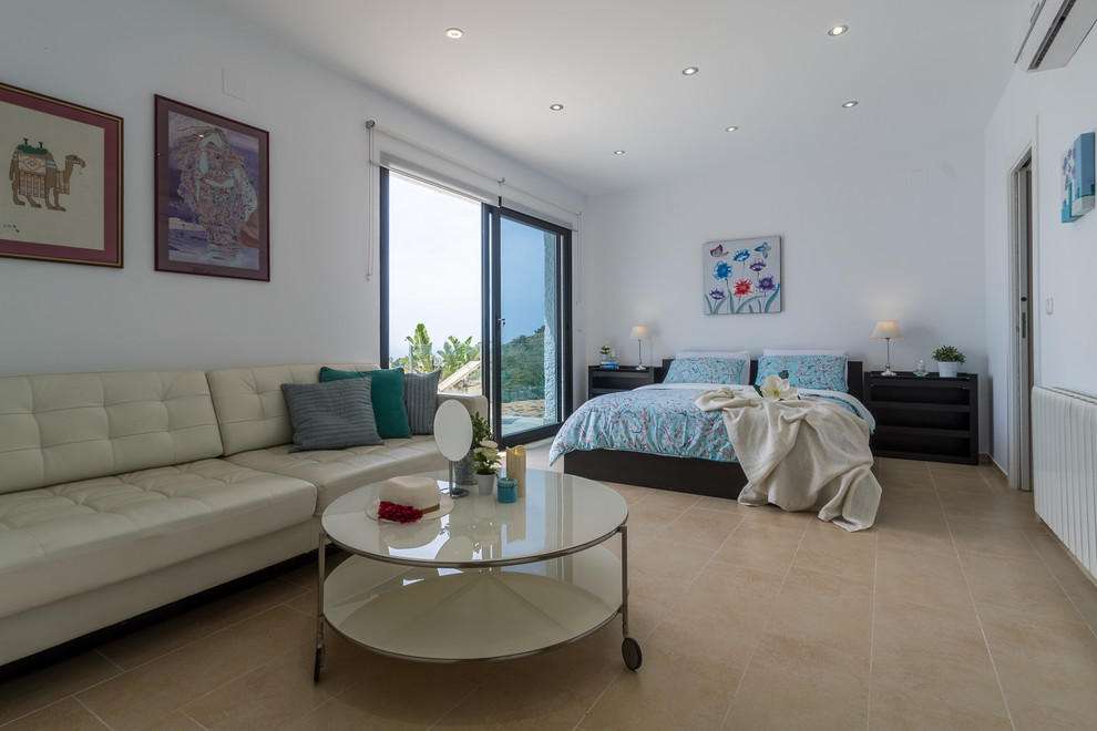 Diseño de habitación de invitados tropical de tamaño medio con paredes blancas, suelo de baldosas de cerámica y suelo beige