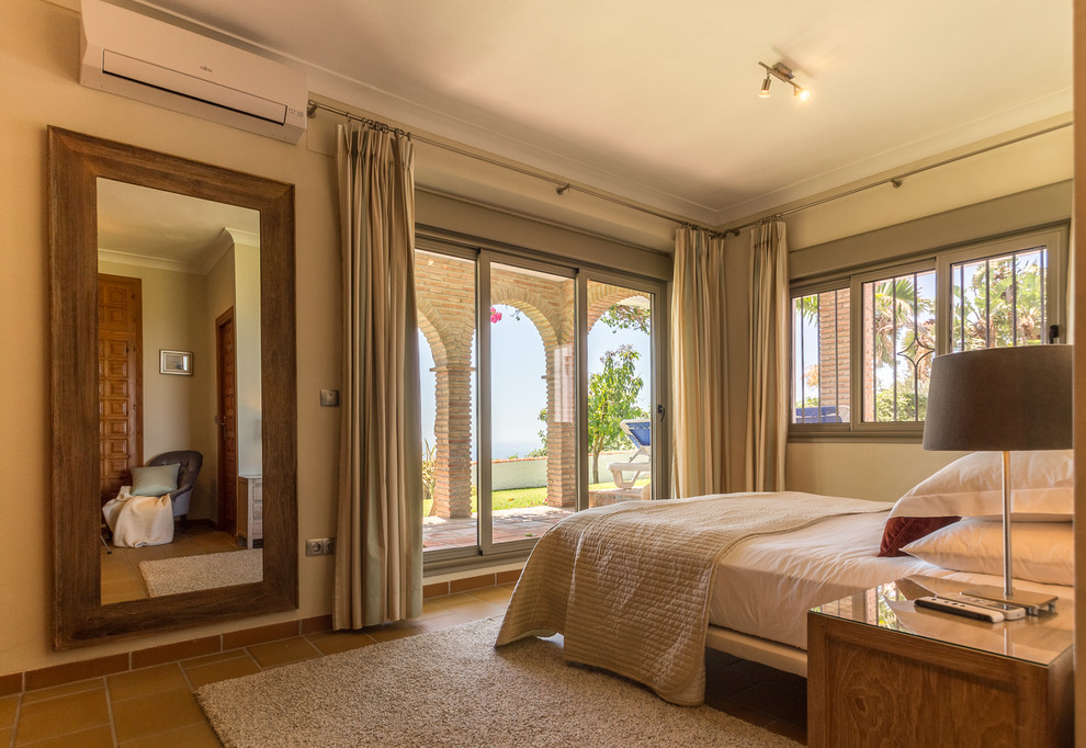 Idee per una camera matrimoniale mediterranea di medie dimensioni con pareti beige, pavimento con piastrelle in ceramica, stufa a legna e pavimento beige