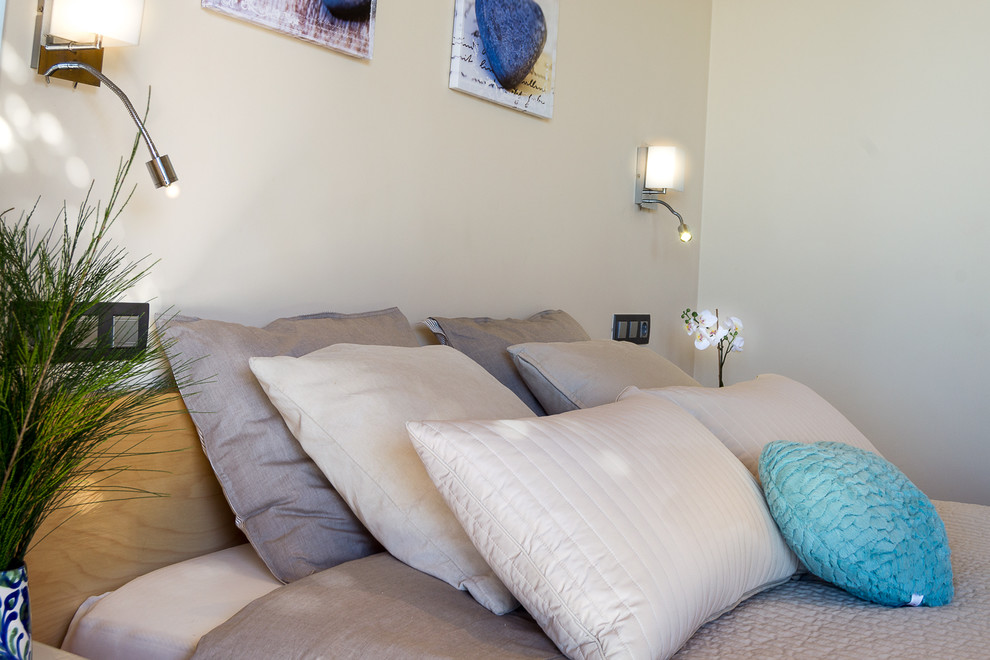 Foto de habitación de invitados mediterránea de tamaño medio con paredes beige, suelo laminado y suelo marrón