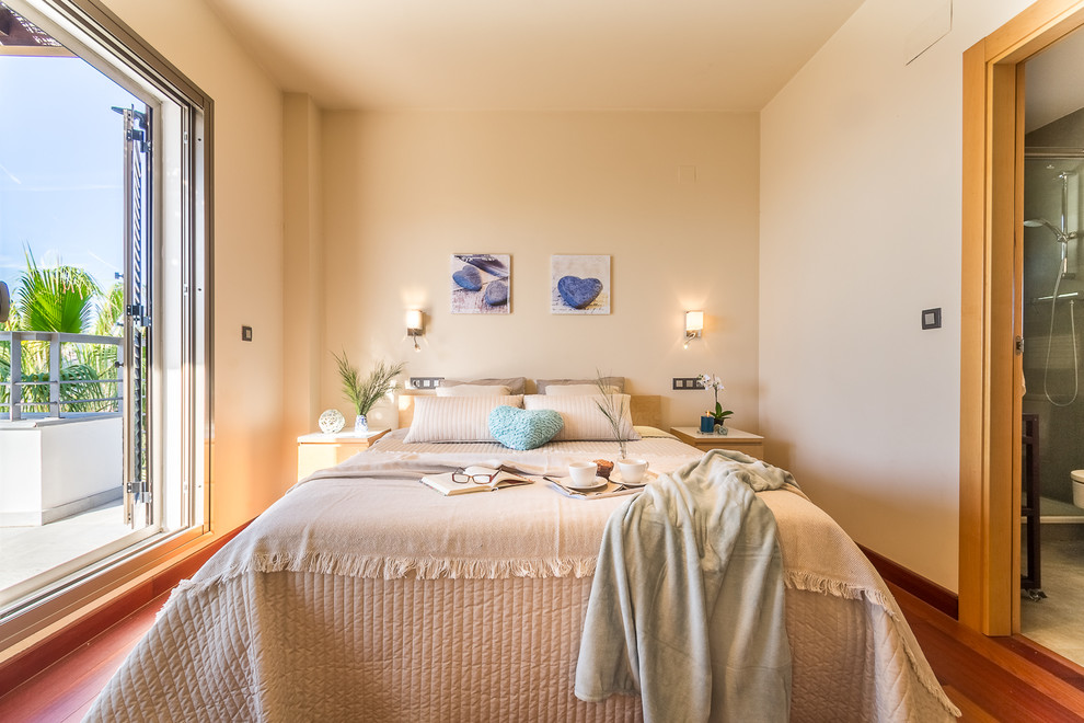 Diseño de habitación de invitados mediterránea de tamaño medio con paredes beige, suelo laminado y suelo marrón