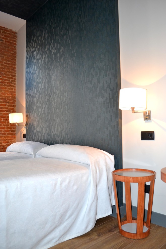 Diseño de habitación de invitados industrial de tamaño medio sin chimenea con paredes multicolor y suelo de madera oscura
