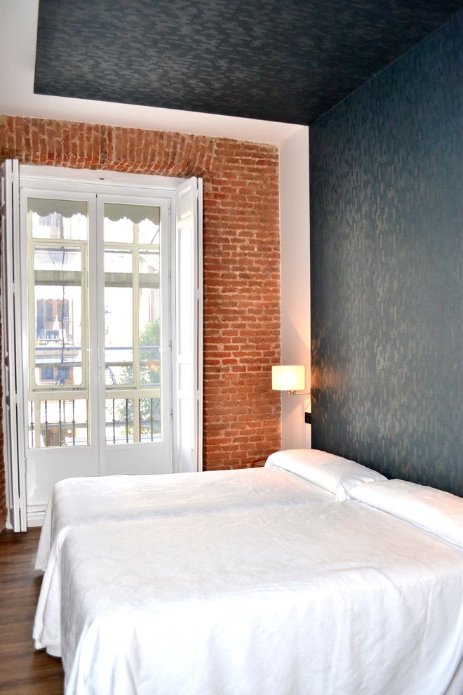 Modelo de habitación de invitados urbana de tamaño medio sin chimenea con paredes multicolor y suelo de madera oscura