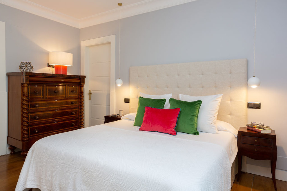 На фото: большая хозяйская спальня в стиле неоклассика (современная классика) с коричневым полом, серыми стенами и паркетным полом среднего тона