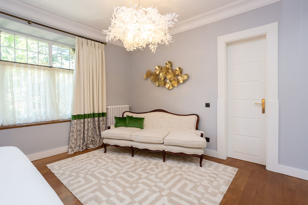 Diseño de dormitorio principal mediterráneo grande con paredes grises, suelo de madera en tonos medios y suelo marrón
