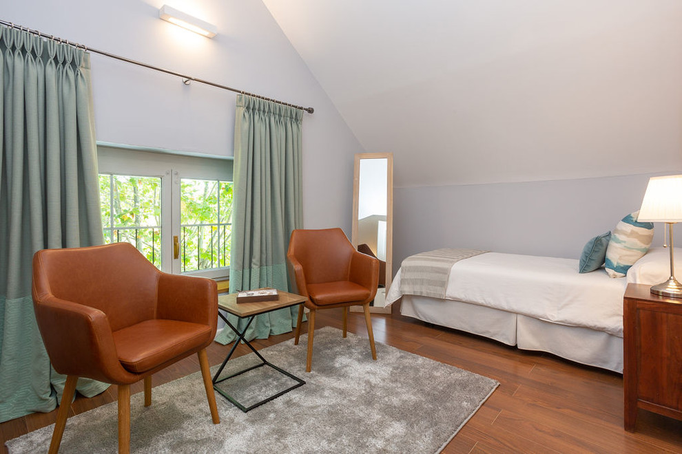 На фото: большая гостевая спальня (комната для гостей) в средиземноморском стиле с серыми стенами, паркетным полом среднего тона и коричневым полом с