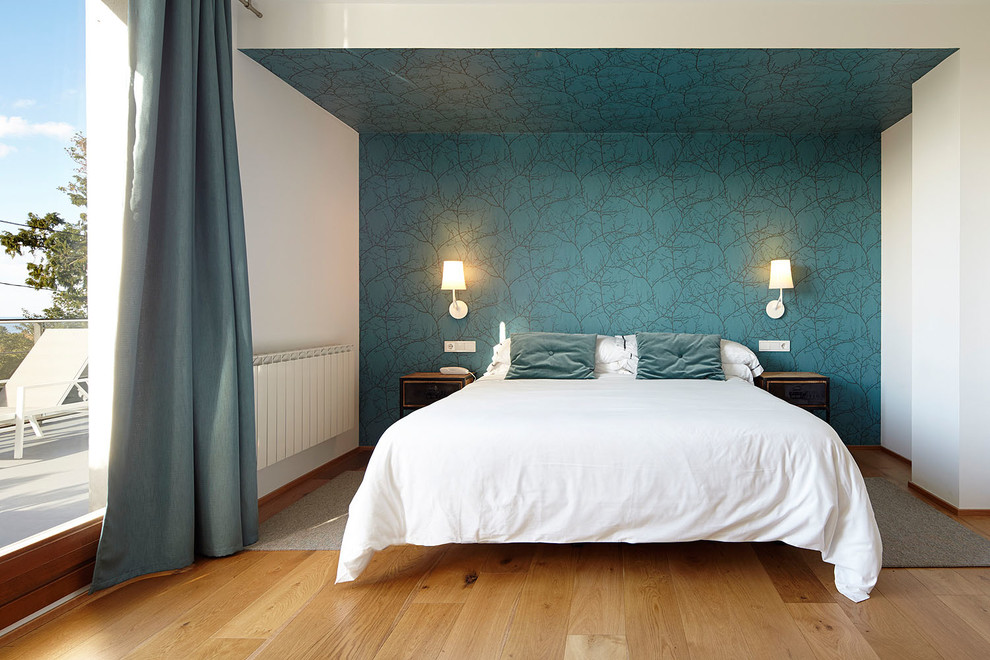 Imagen de dormitorio principal contemporáneo de tamaño medio sin chimenea con paredes multicolor y suelo de madera en tonos medios