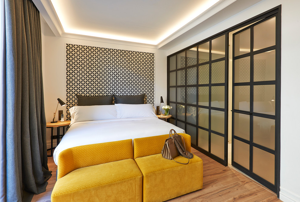 Mittelgroßes Modernes Hauptschlafzimmer ohne Kamin mit weißer Wandfarbe und hellem Holzboden in Barcelona