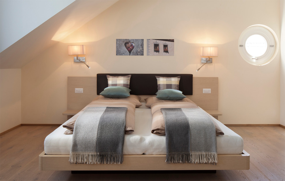 Idee per una camera da letto minimal con pareti beige e parquet chiaro