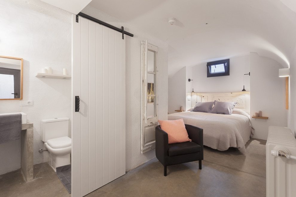 Foto de dormitorio principal mediterráneo de tamaño medio sin chimenea con paredes blancas y suelo de cemento