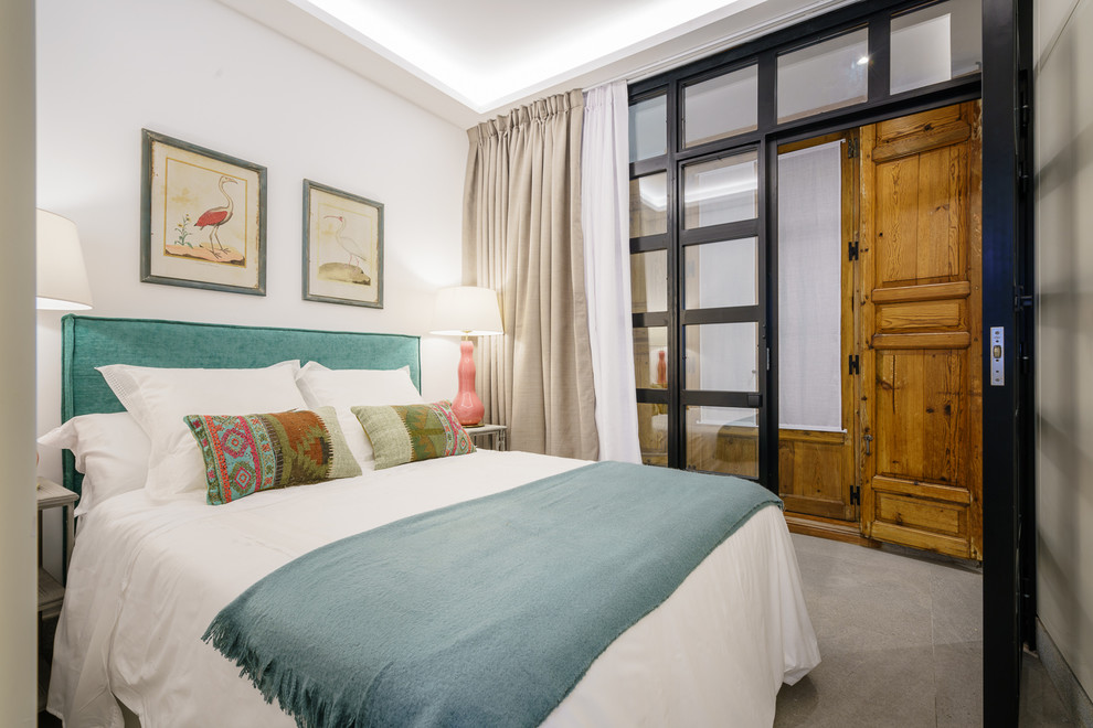 Foto de dormitorio principal mediterráneo de tamaño medio con paredes blancas, suelo gris y moqueta
