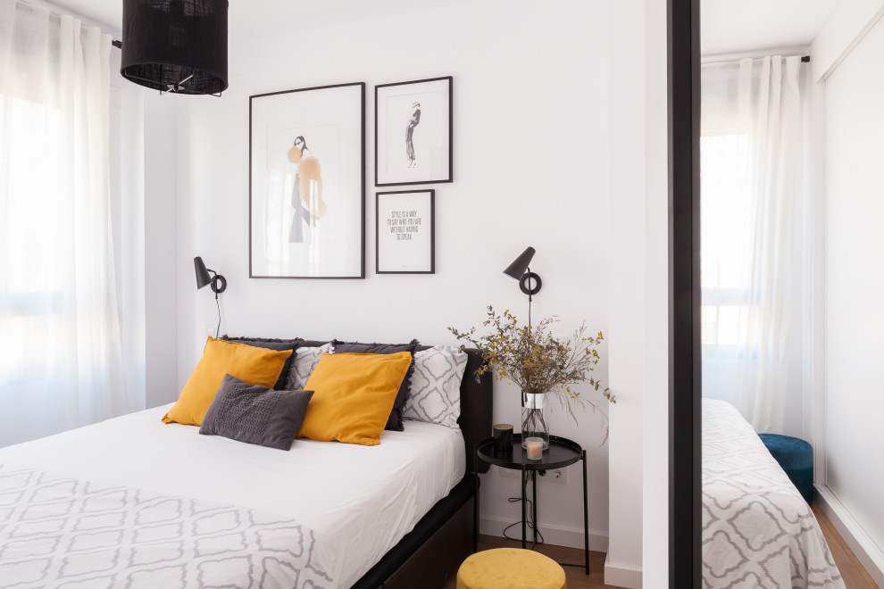 Imagen de dormitorio principal contemporáneo pequeño con paredes blancas, suelo de madera en tonos medios y suelo marrón