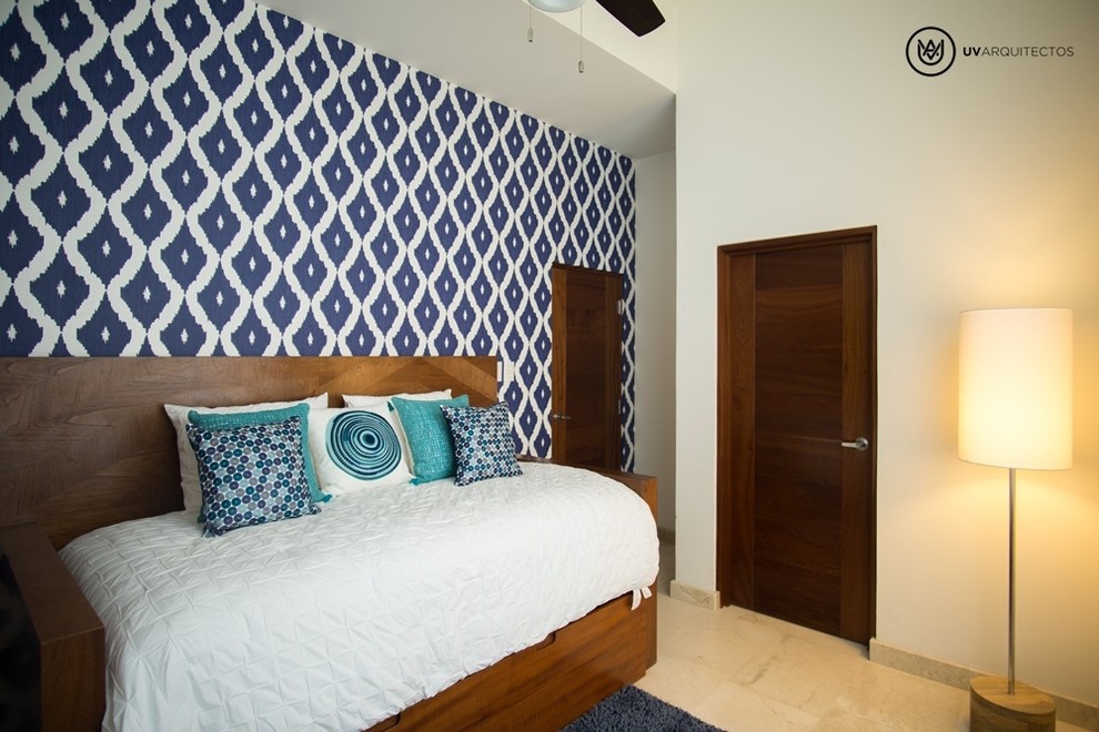 Foto de habitación de invitados moderna grande con paredes azules y suelo de travertino