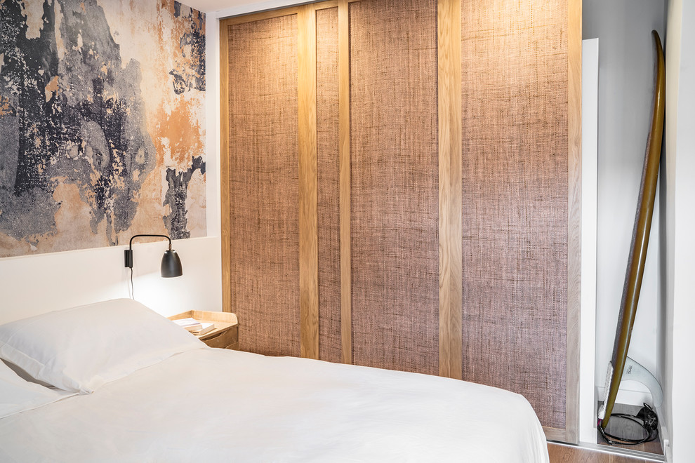 Imagen de habitación de invitados mediterránea de tamaño medio con paredes blancas y suelo de madera clara
