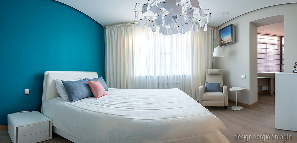 Modelo de dormitorio principal costero de tamaño medio sin chimenea con paredes multicolor y suelo de madera en tonos medios