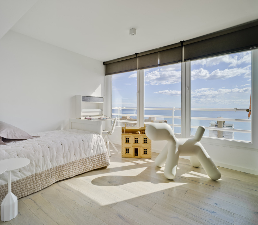 Medium sized coastal master bedroom in Alicante-Costa Blanca with white walls, light hardwood flooring and no fireplace.