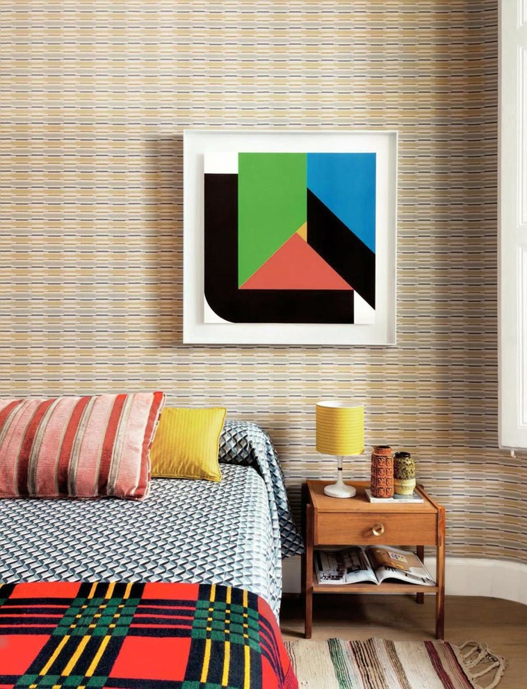 Foto på ett sovrum, med flerfärgade väggar och ljust trägolv
