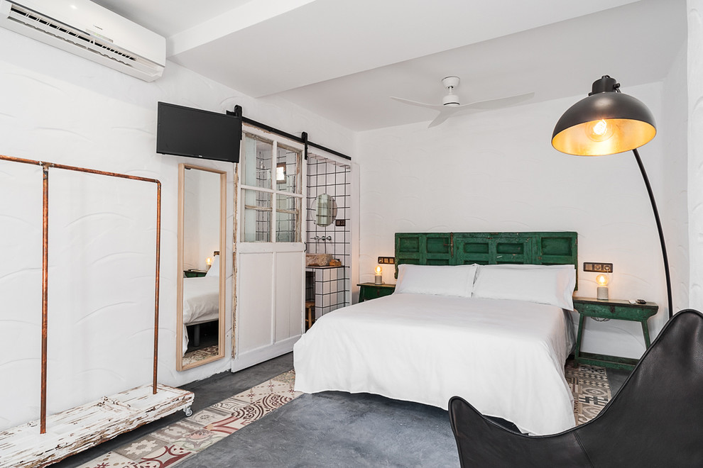 Ejemplo de dormitorio principal mediterráneo con paredes blancas, suelo de cemento y suelo gris