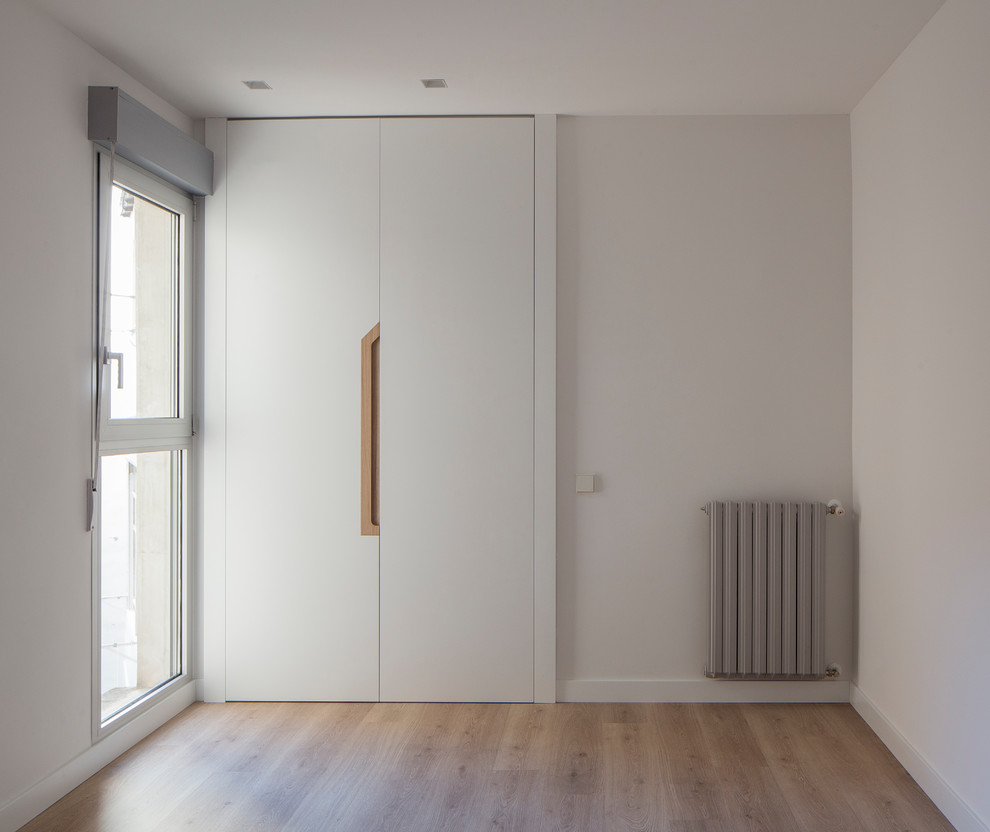 Inspiration för ett mellanstort minimalistiskt gästrum, med vita väggar och ljust trägolv