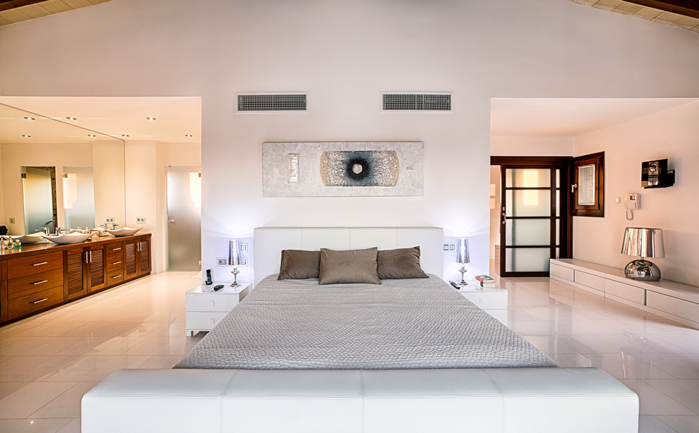 Modelo de dormitorio principal mediterráneo grande con paredes blancas y suelo de mármol
