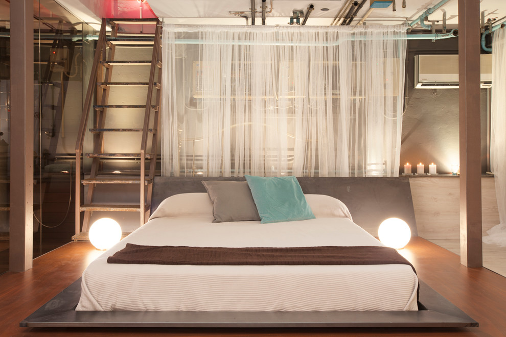 Modelo de dormitorio principal industrial de tamaño medio sin chimenea con suelo de madera en tonos medios