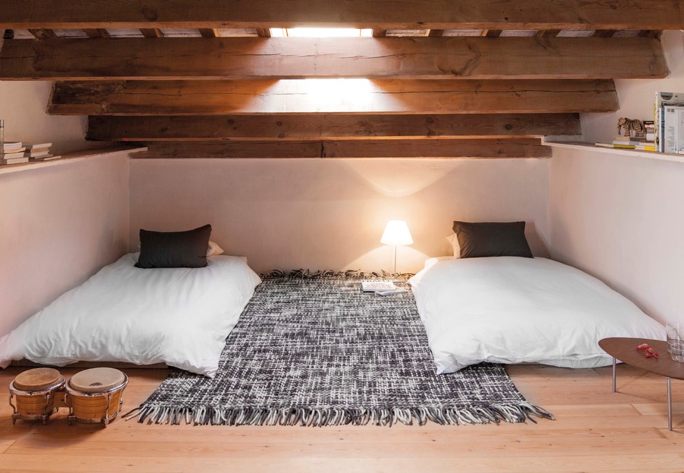 Modelo de habitación de invitados mediterránea de tamaño medio sin chimenea con paredes blancas y suelo de madera clara