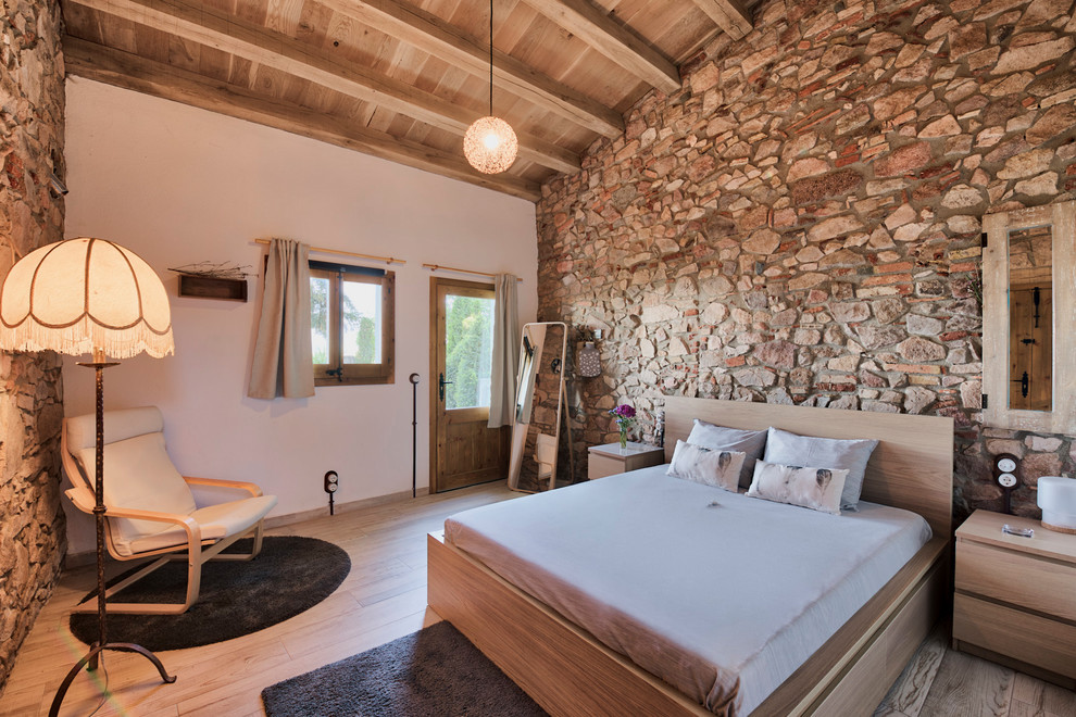 Modelo de dormitorio rústico sin chimenea con paredes blancas y suelo de madera clara