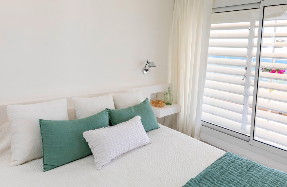 Стильный дизайн: большая гостевая спальня (комната для гостей) в средиземноморском стиле с белыми стенами, бетонным полом и серым полом - последний тренд