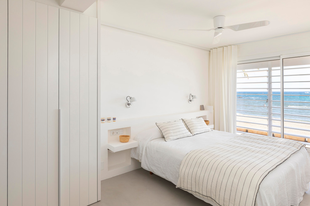 Diseño de dormitorio principal mediterráneo grande con paredes blancas, suelo de cemento y suelo gris