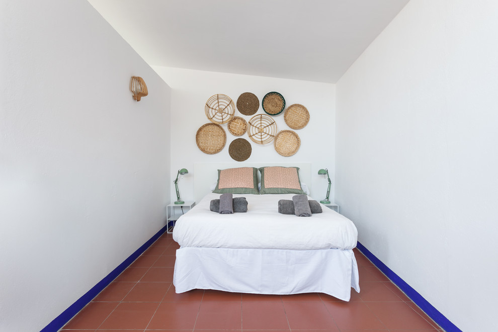 Photo of a medium sized nautical mezzanine bedroom in Barcelona with white walls, terracotta flooring, no fireplace and red floors.