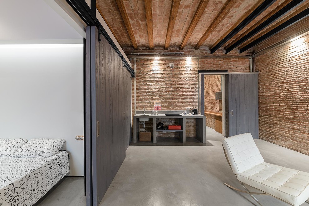 Imagen de dormitorio principal industrial de tamaño medio sin chimenea con paredes blancas y suelo de cemento