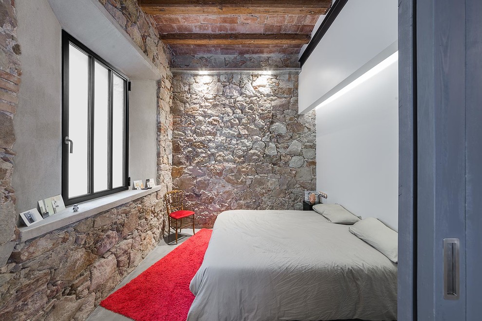 Idées déco pour une chambre parentale industrielle de taille moyenne avec un mur blanc, sol en béton ciré et aucune cheminée.