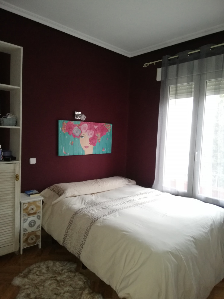 Foto de dormitorio principal clásico renovado de tamaño medio sin chimenea con paredes rojas, suelo de madera clara y suelo marrón
