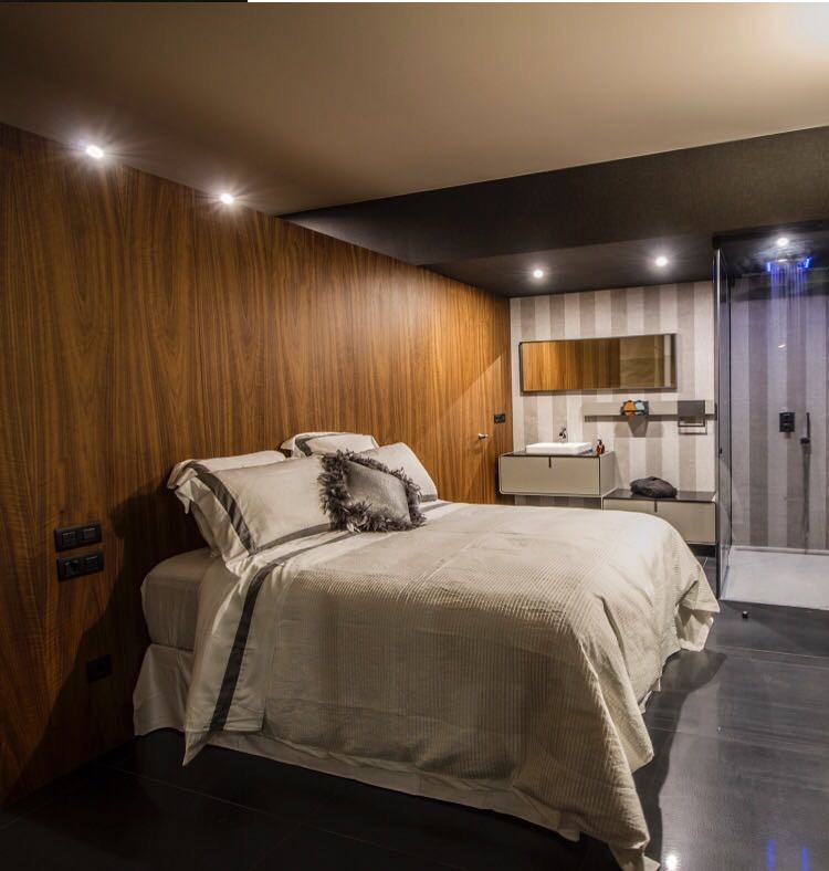 Идея дизайна: большая хозяйская спальня в современном стиле с коричневыми стенами, мраморным полом и черным полом без камина