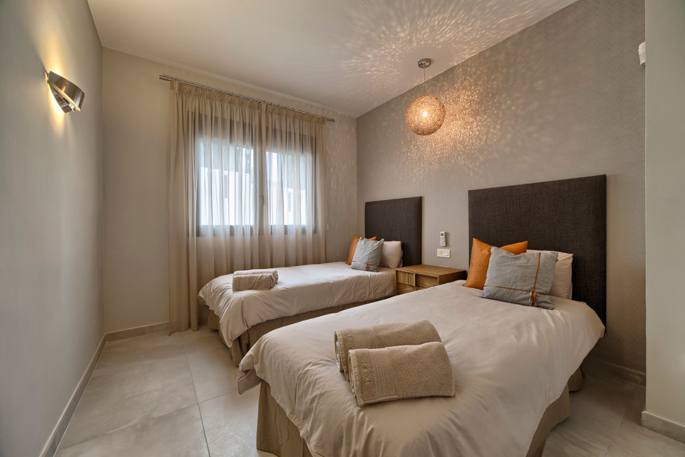 Diseño de habitación de invitados contemporánea de tamaño medio sin chimenea con paredes beige y suelo de baldosas de cerámica