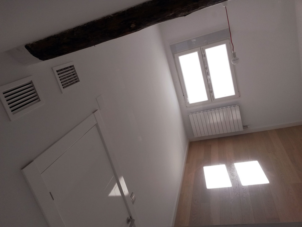 Imagen de habitación de invitados minimalista de tamaño medio con paredes blancas y suelo de madera clara