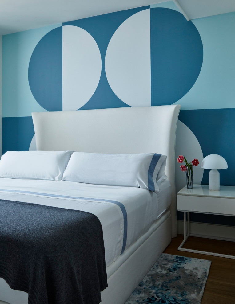 Foto de dormitorio contemporáneo con paredes azules, suelo de madera en tonos medios y suelo marrón