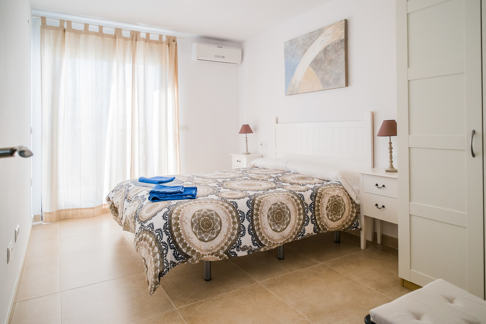 Esempio di una camera matrimoniale mediterranea di medie dimensioni con pareti bianche, pavimento con piastrelle in ceramica e nessun camino